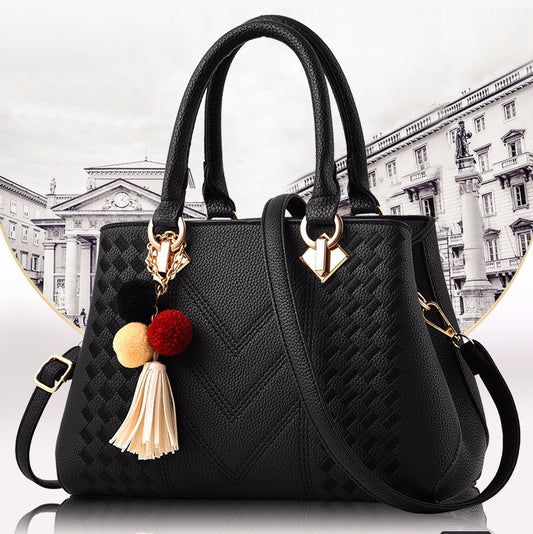 Luxury Ladies Handbags stylish black crossbody bag with decorative tassel and pom-poms.